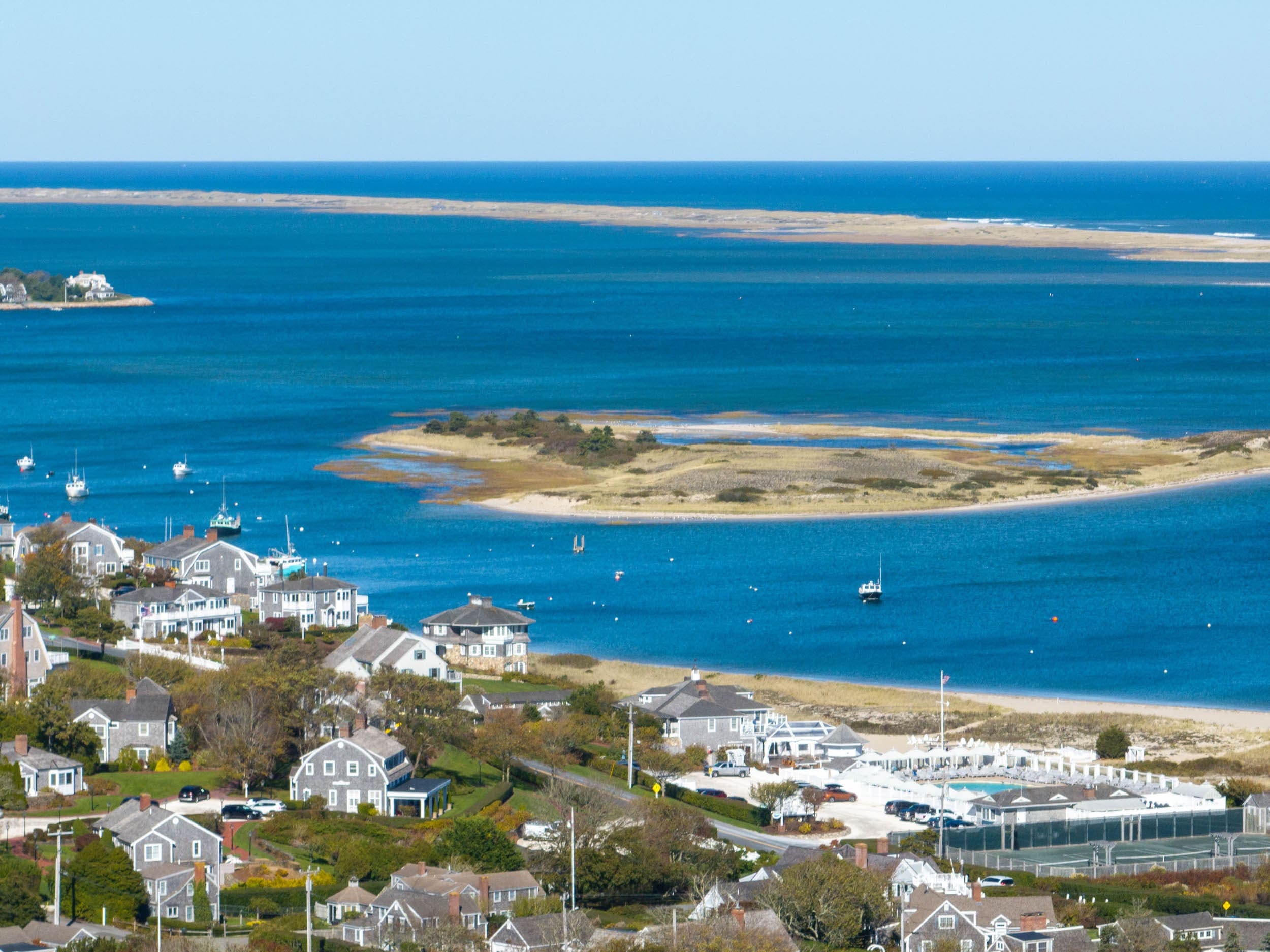 An aerial view of Cape Cod with boats in the water and waterside homes