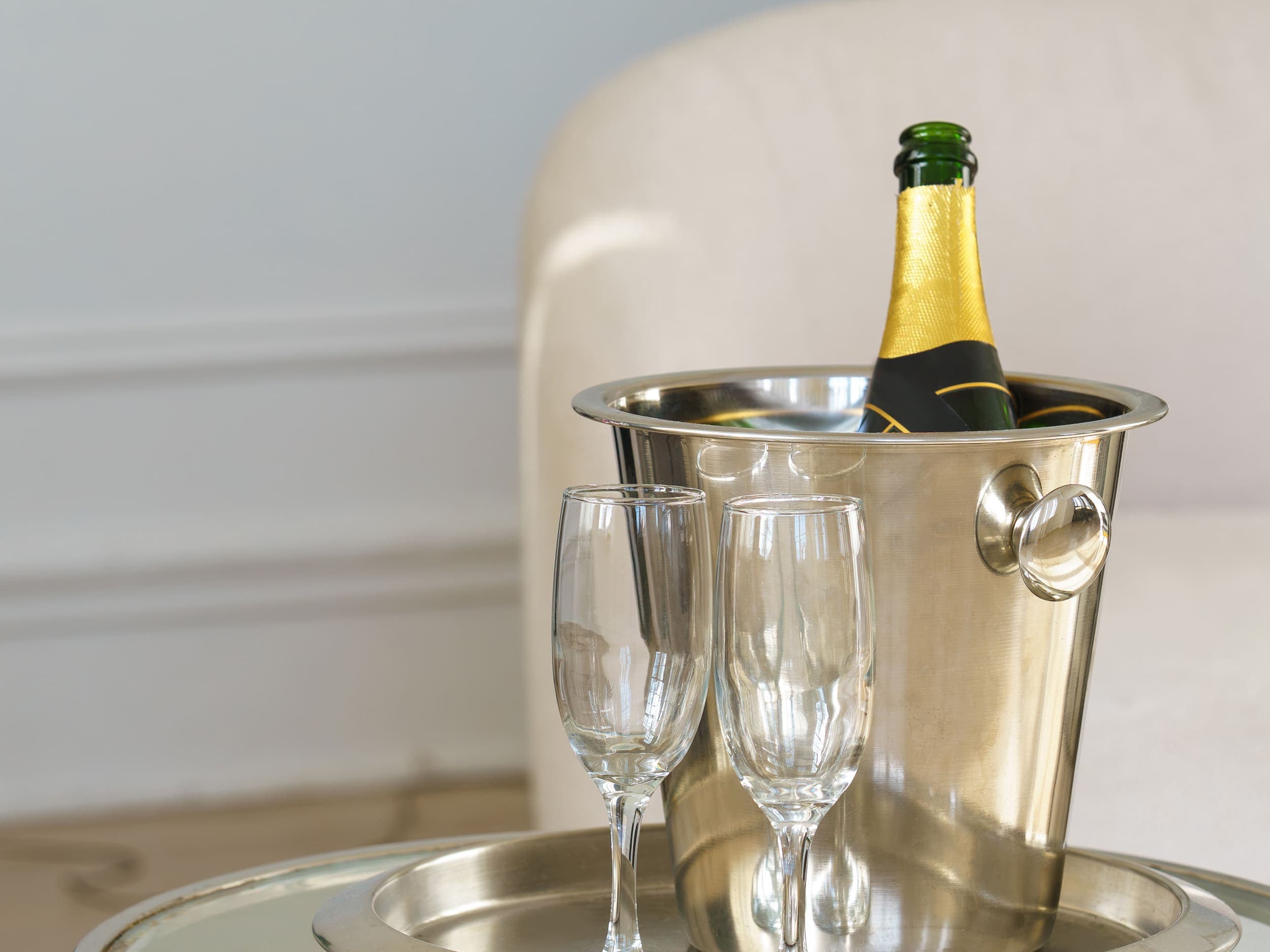 A bottle of sparkling with two glasses on a serving tray in a room at the Chatham Inn