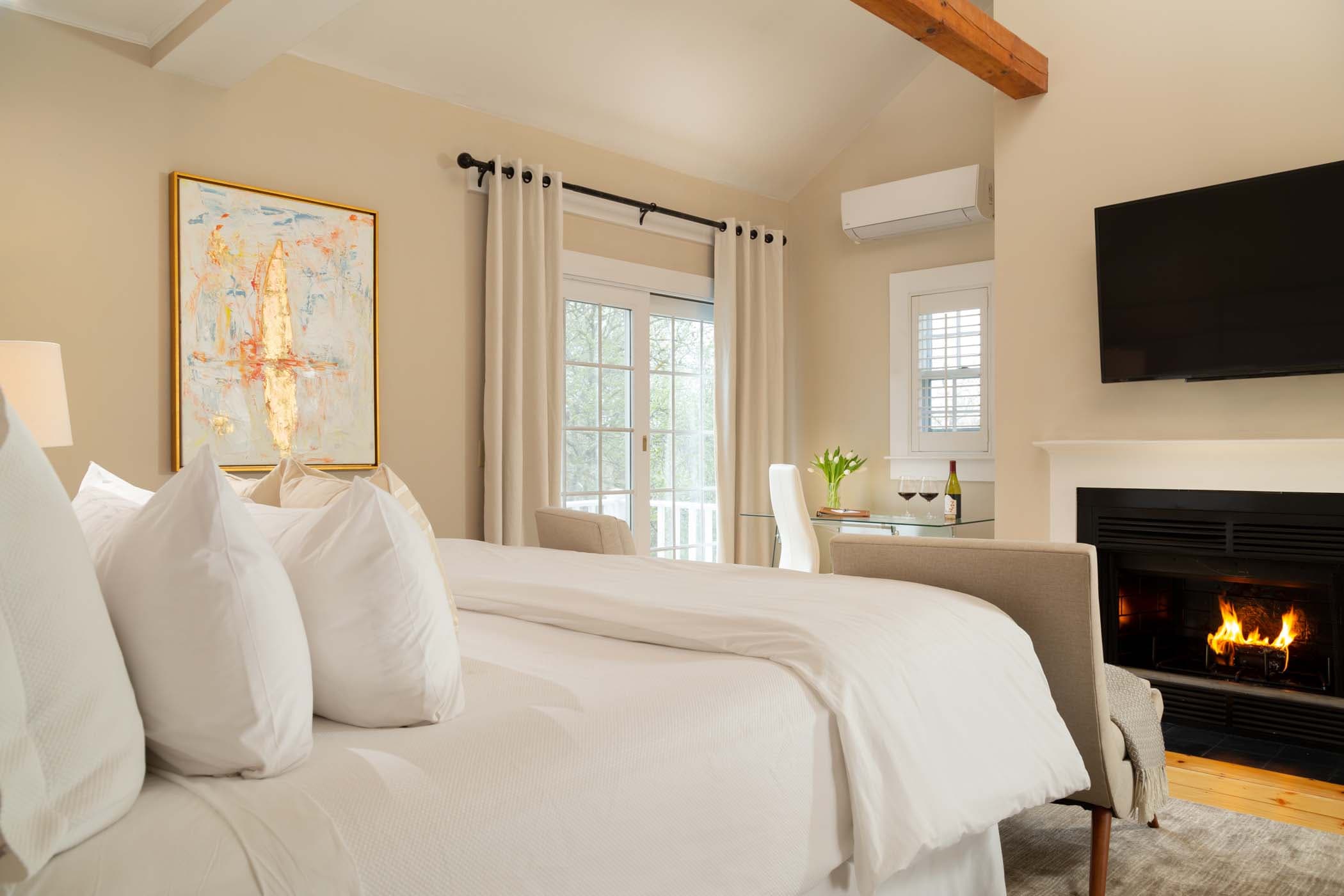 A room with gorgeous wall art, a fireplace and a large bed at Chatham Inn