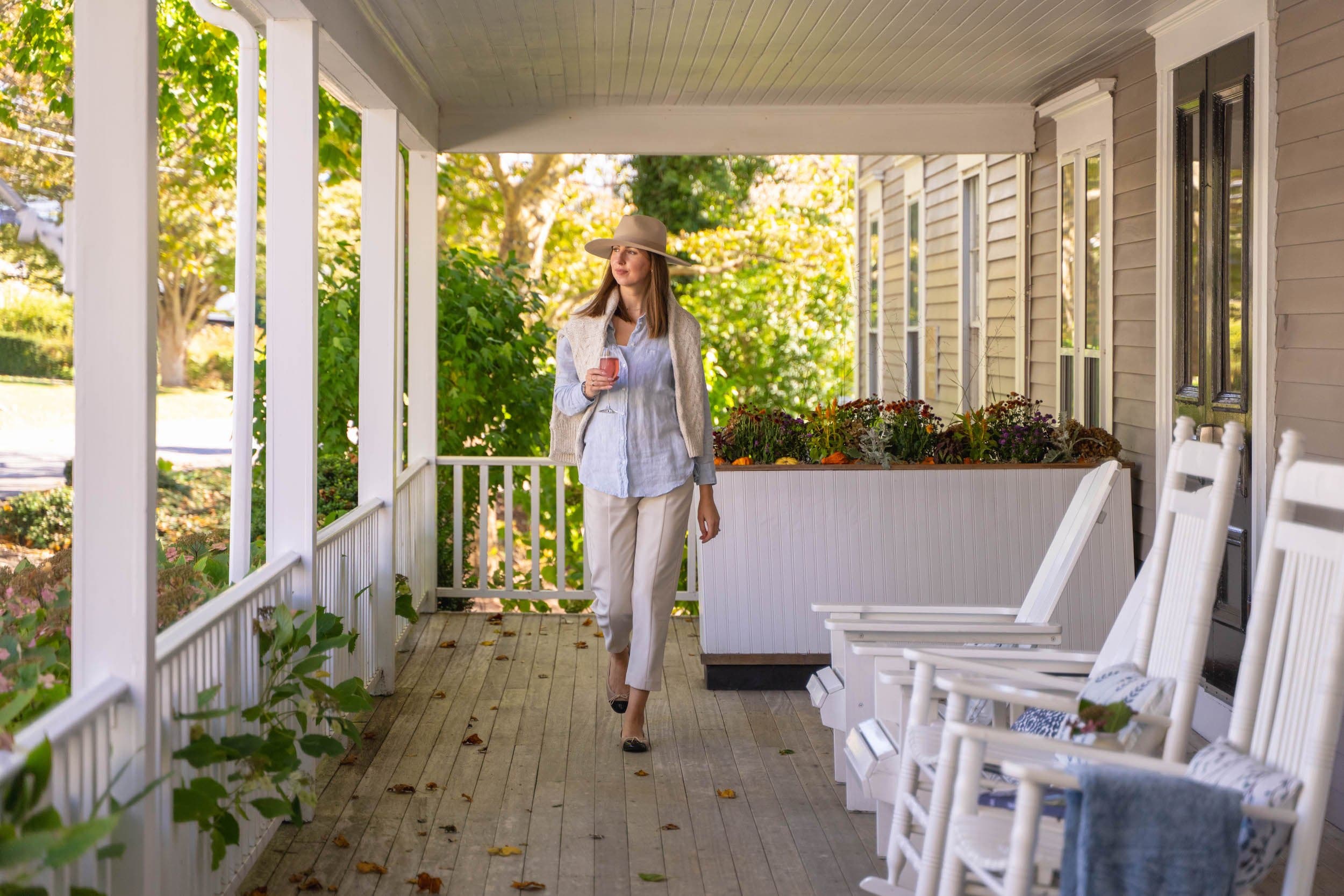 A woman walking on a deck with a glass of rosé at The Chatham Inn