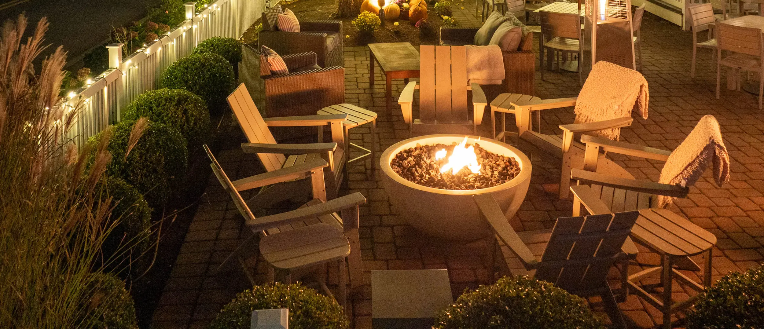 A fire pit at Chatham with 6 patio chairs around it